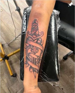Black and grey traditional dagger and banner tattoo by Aaron Raines