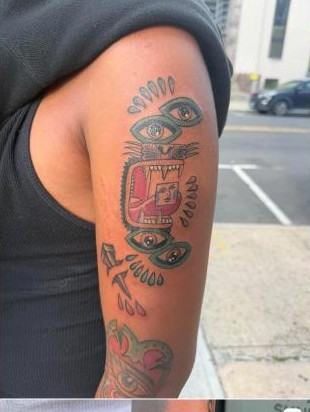 Bold color mask-style tattoo with eye details, by Aaron Raines