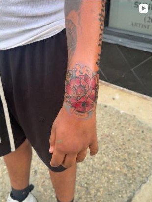 Color traditional lotus flower wrist tattoo by Aaron Raines