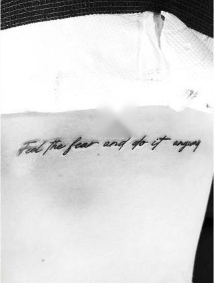 Fine-line script tattoo reading "Feel the fear and do it anyway," by Aaron Raines