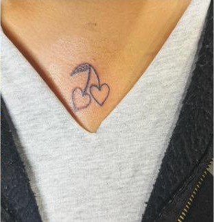 Fine-line cherries and heart chest tattoo by Aaron Raines