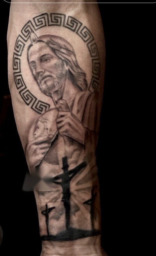 Black and grey Jesus portrait and three crosses forearm piece
